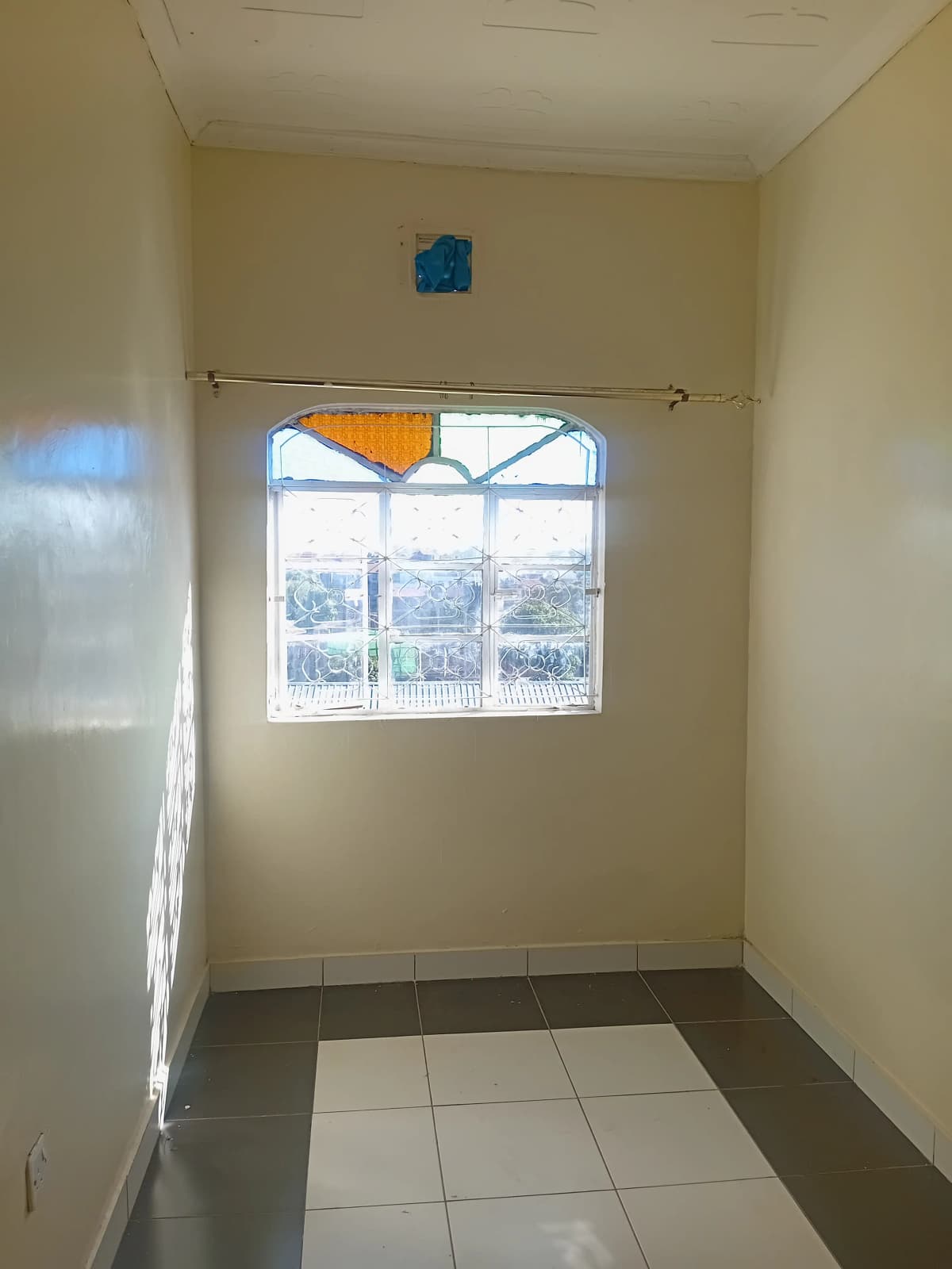 Bright bedroom with large window and tiled flooring