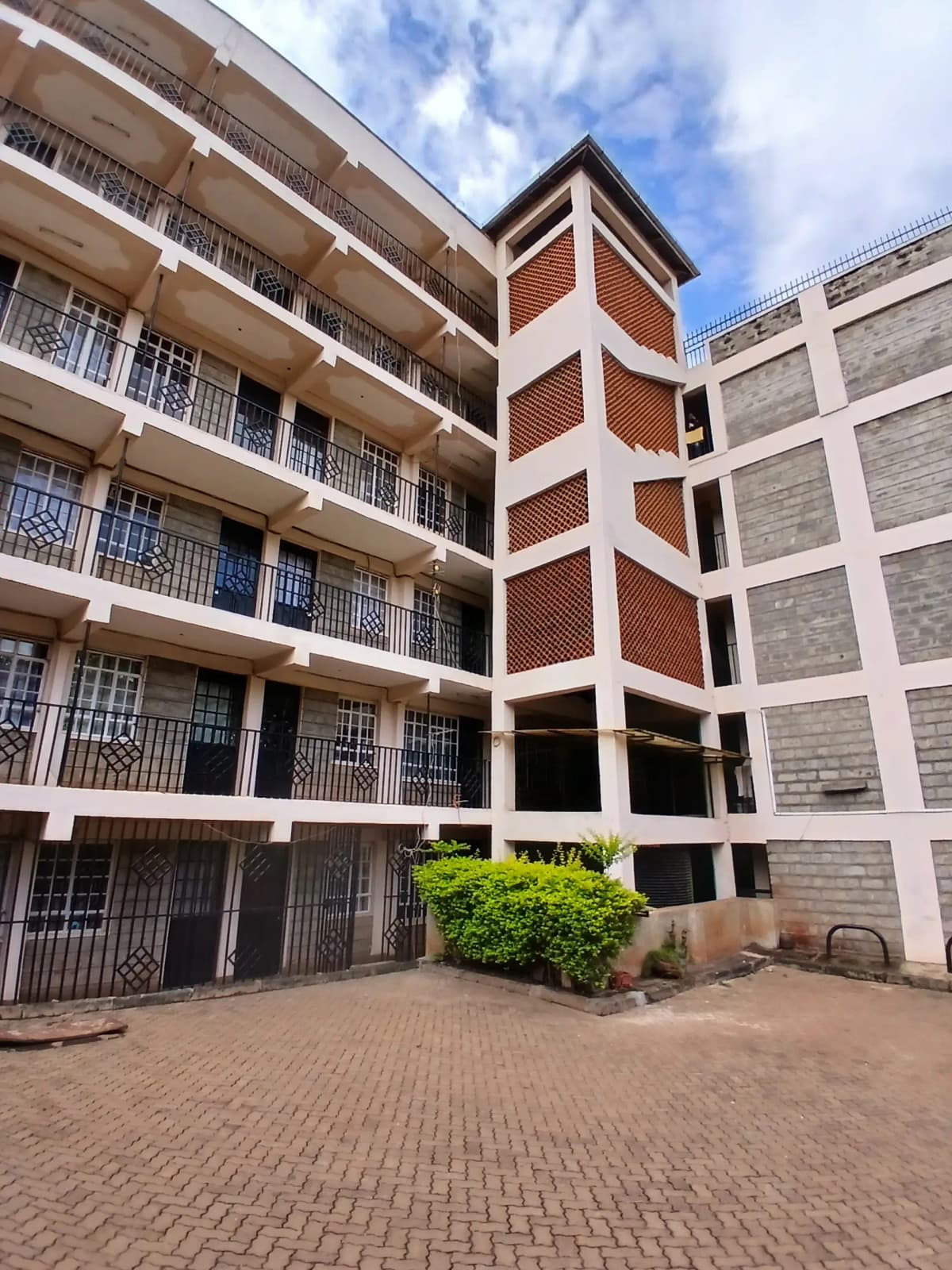 Multi-story residential building courtyard with brick paving