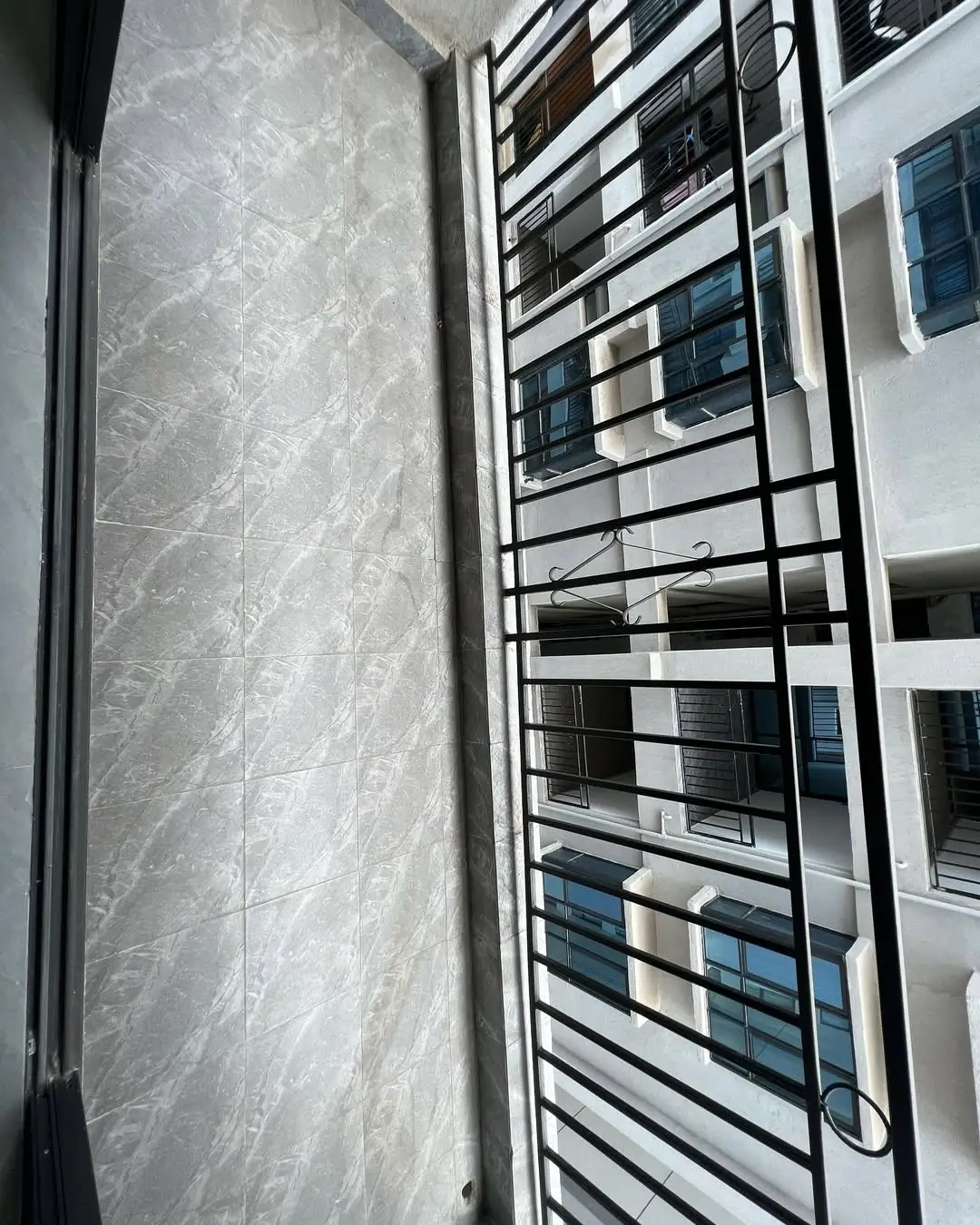 Balcony with metal railing overlooking residential building