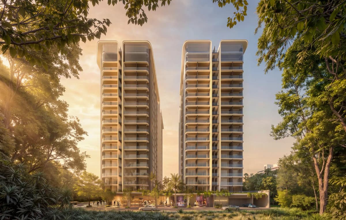 Twin high-rise towers at golden hour amid lush trees