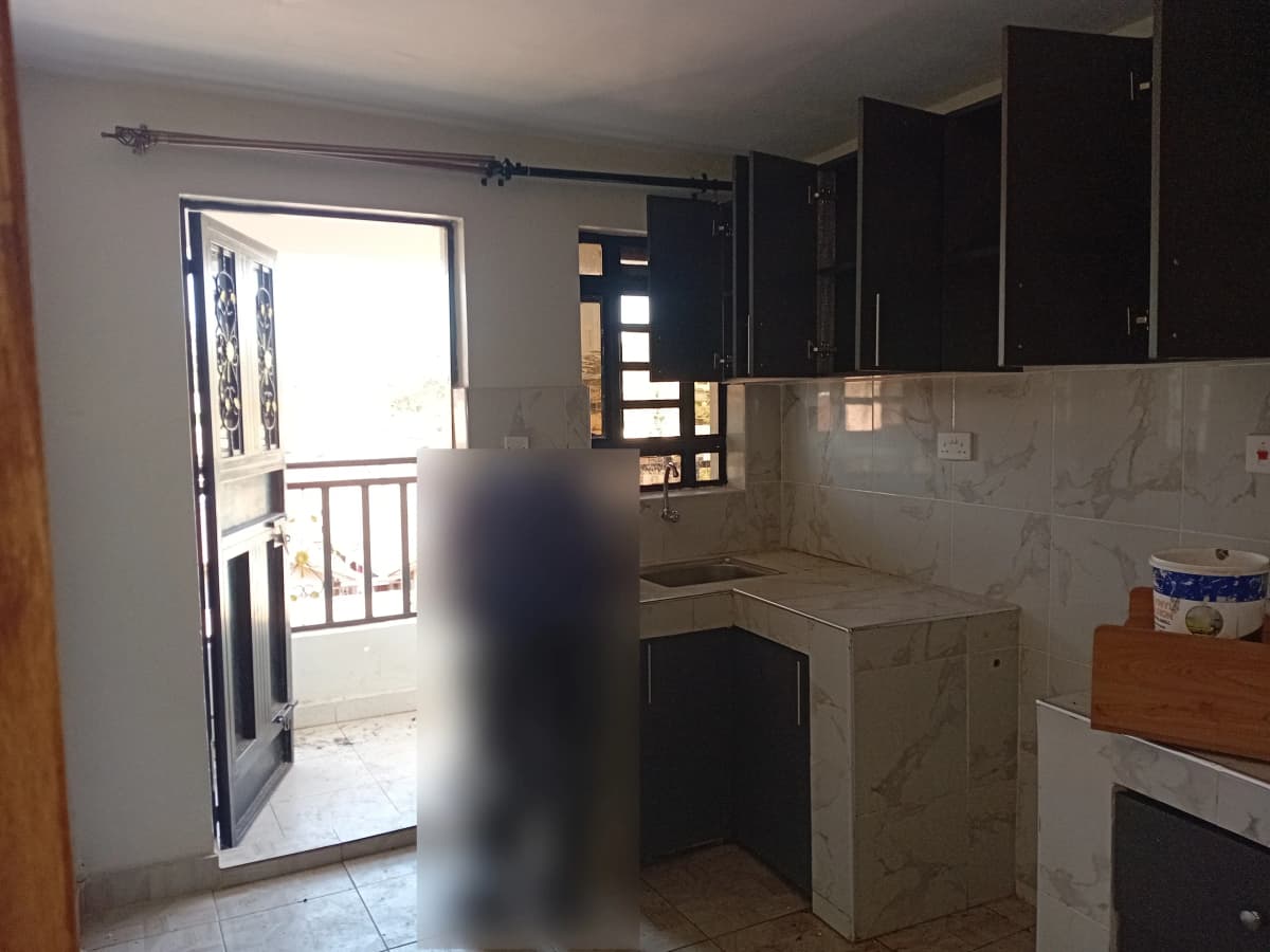 Open-plan kitchen with balcony access and dark cabinetry