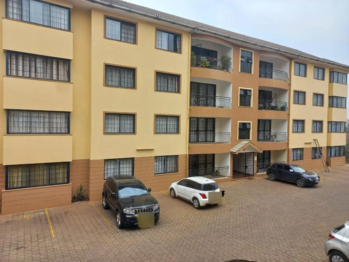 Multi-story residential building facade with parking compound