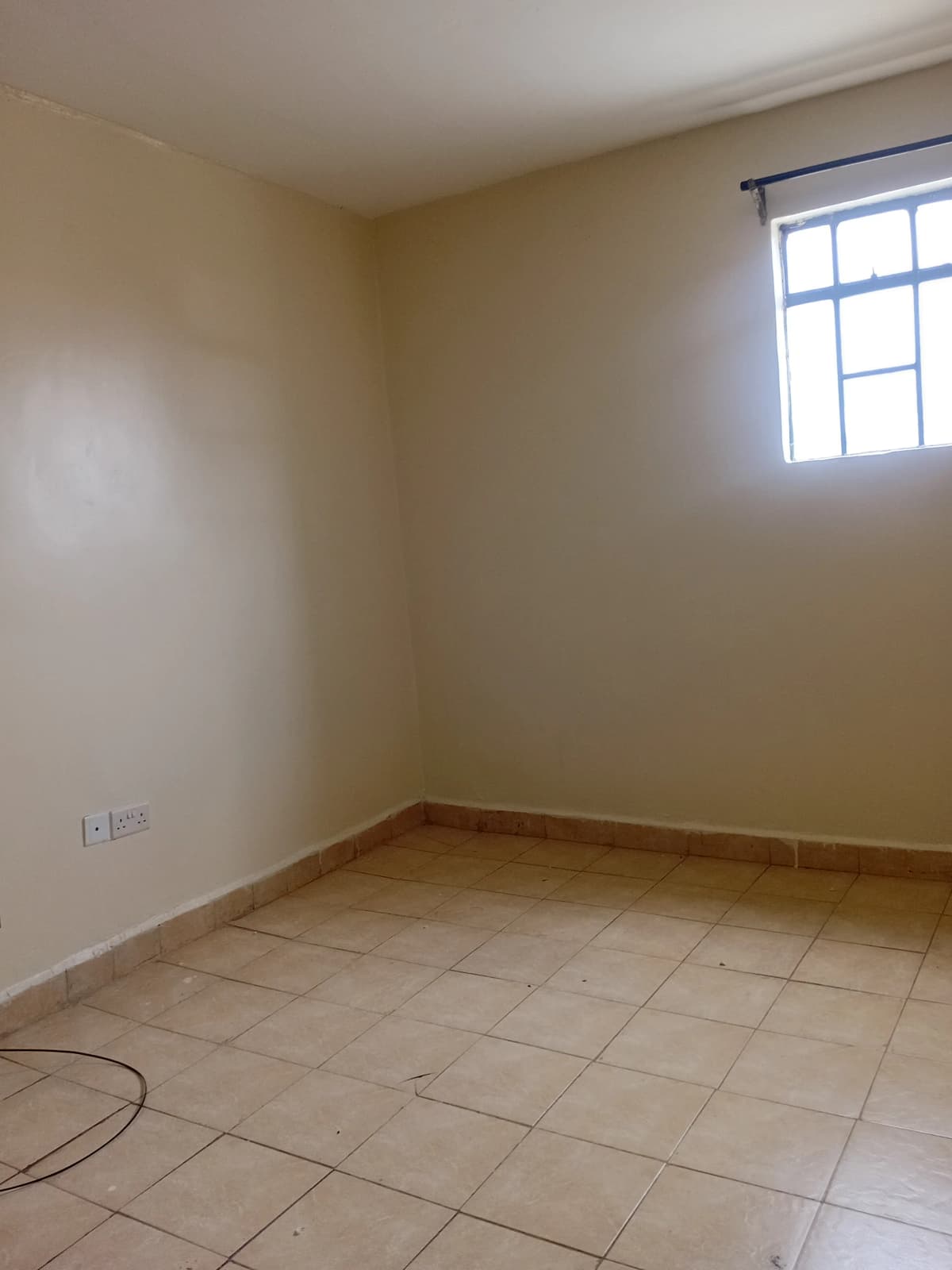 Unfurnished bedroom with tiled floor and natural light