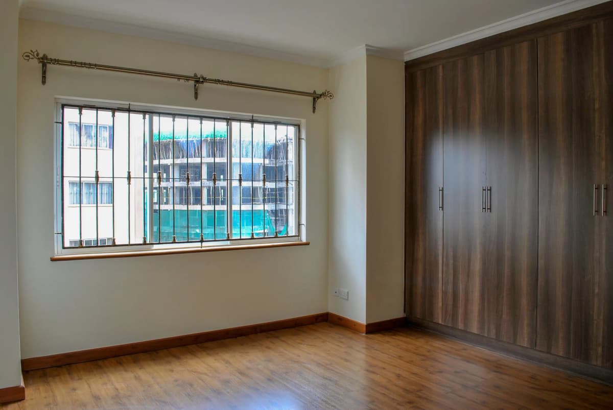 Spacious bedroom with wooden flooring and built-in wardrobes