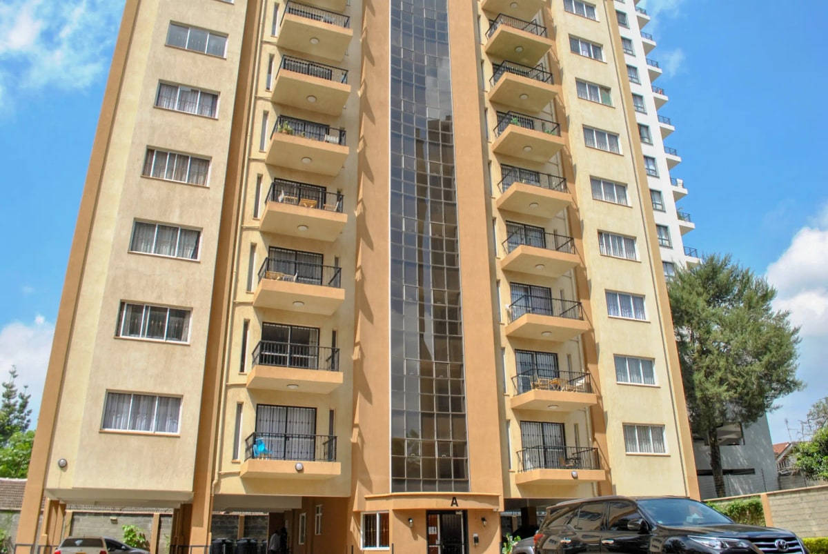 Multi-story residential building facade with balconies and ground parking