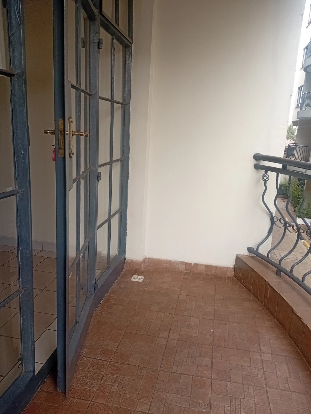 Narrow balcony with terracotta tiles and metal railing