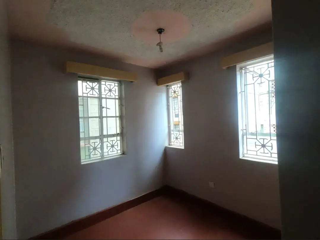 Unfurnished bedroom with decorative barred windows and terracotta tile flooring