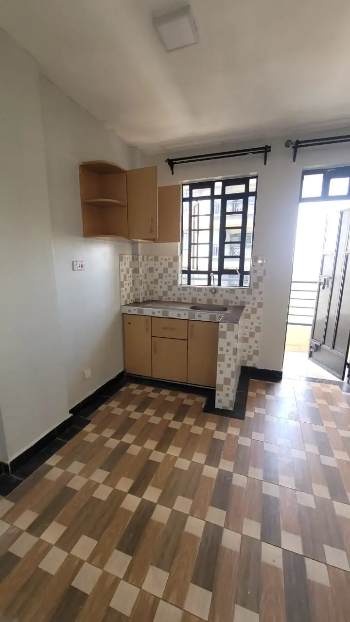 Compact kitchen with wooden cabinets and checkered floor