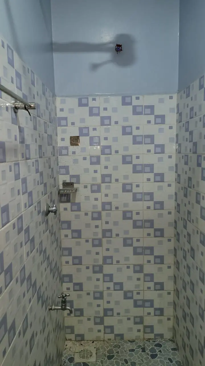 Compact shower stall with purple-white checkered tile walls