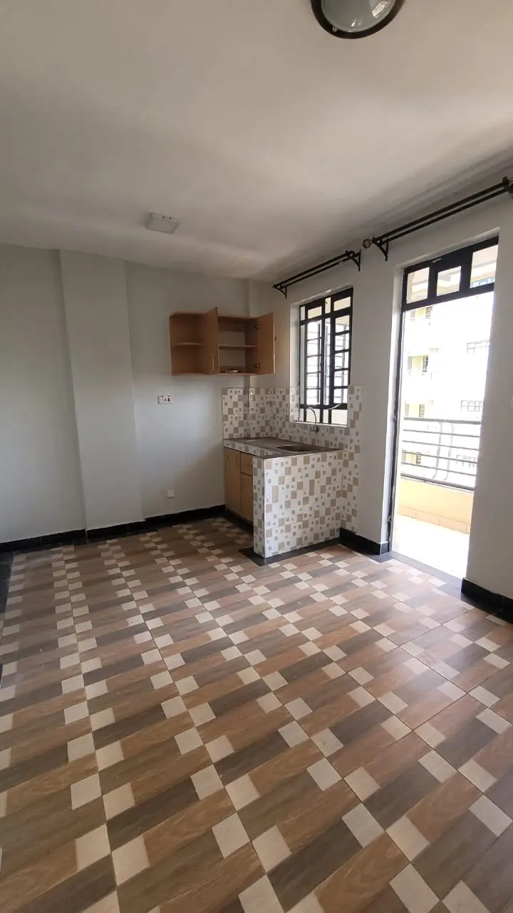 Compact kitchen with geometric tile floor and balcony access