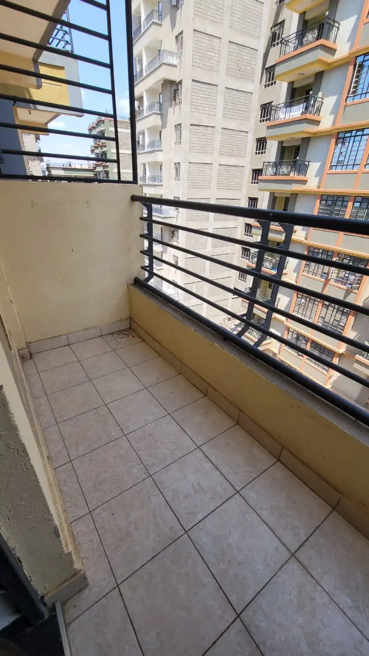 Tiled balcony with metal railing overlooking residential buildings