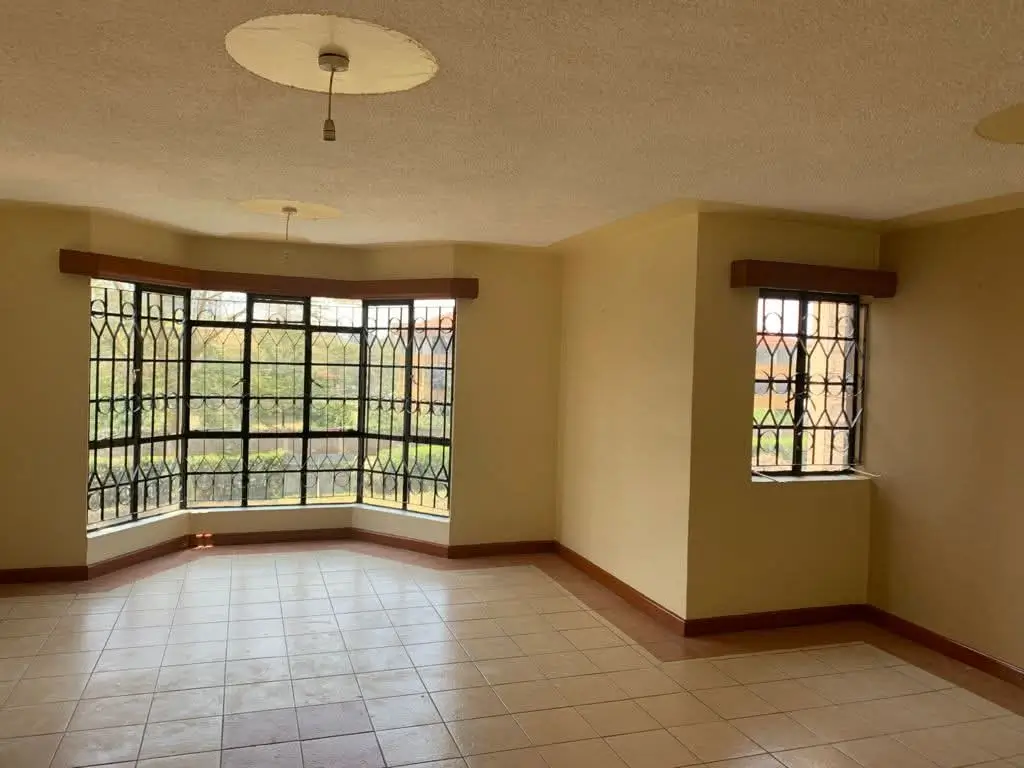 Spacious living room with large corner windows and tile flooring