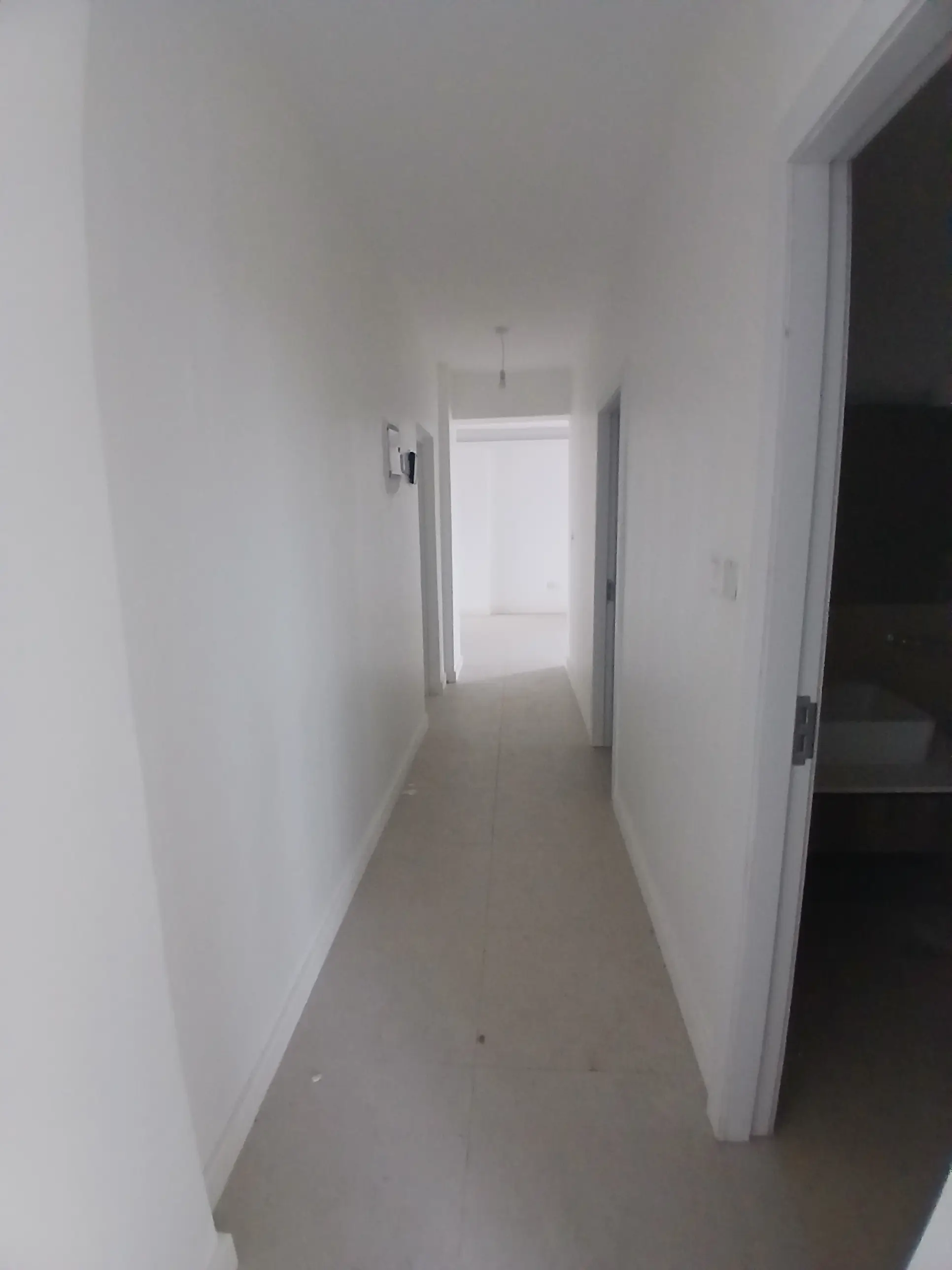 Long white hallway with natural light from end window