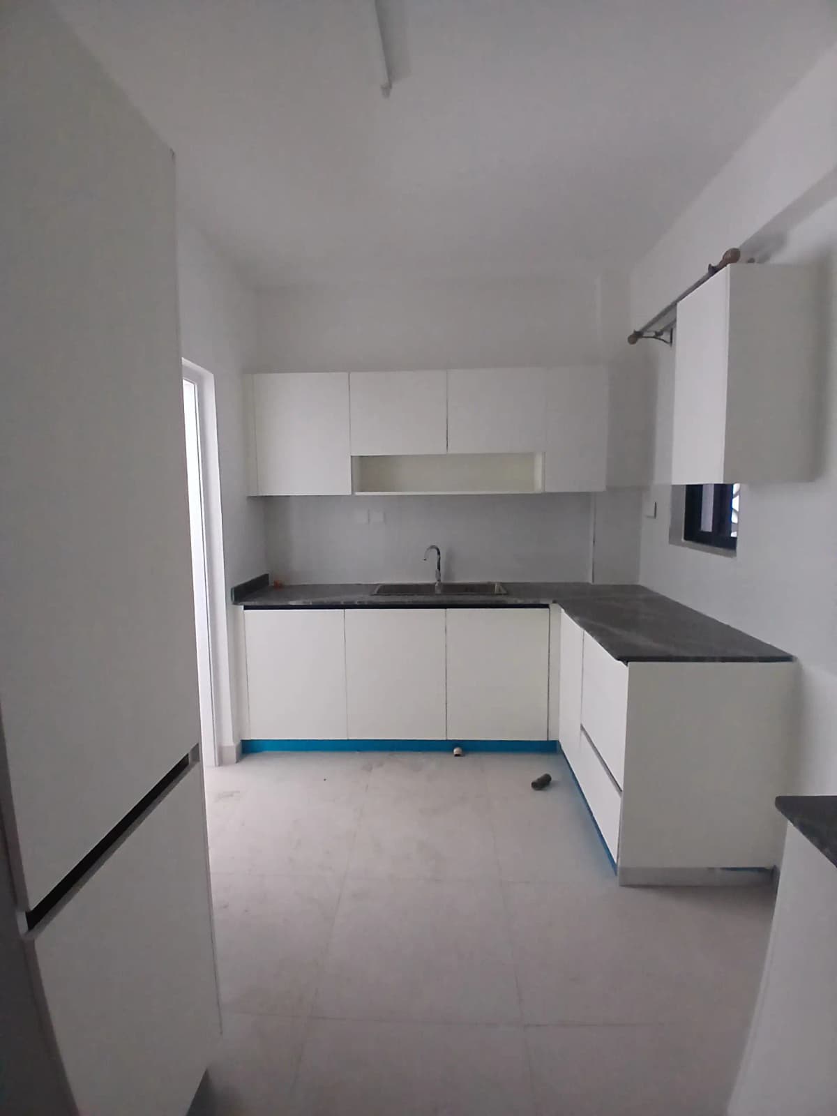 Modern white kitchen with black countertops and built-in appliances