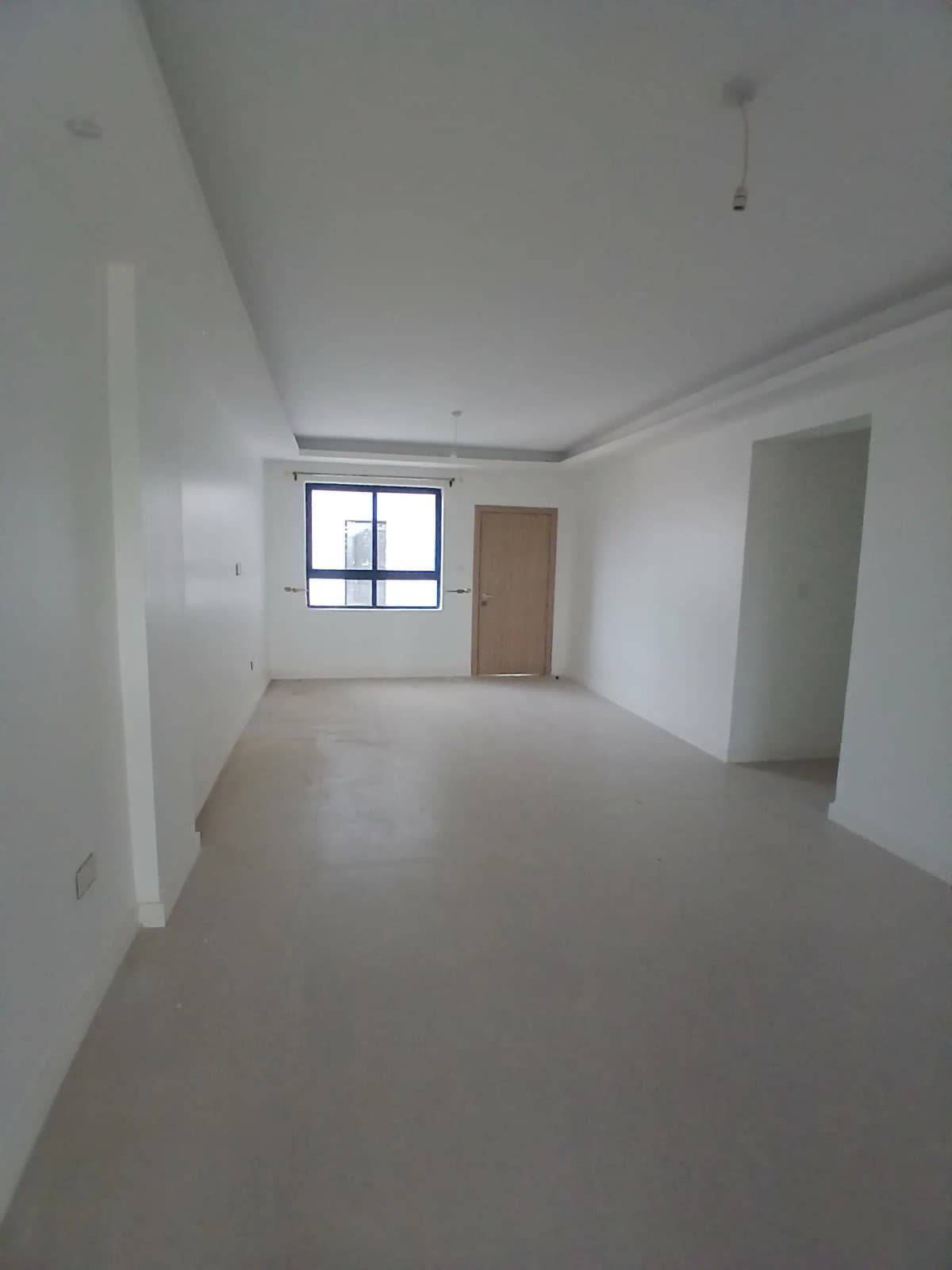 Spacious empty living room with window and neutral finishes
