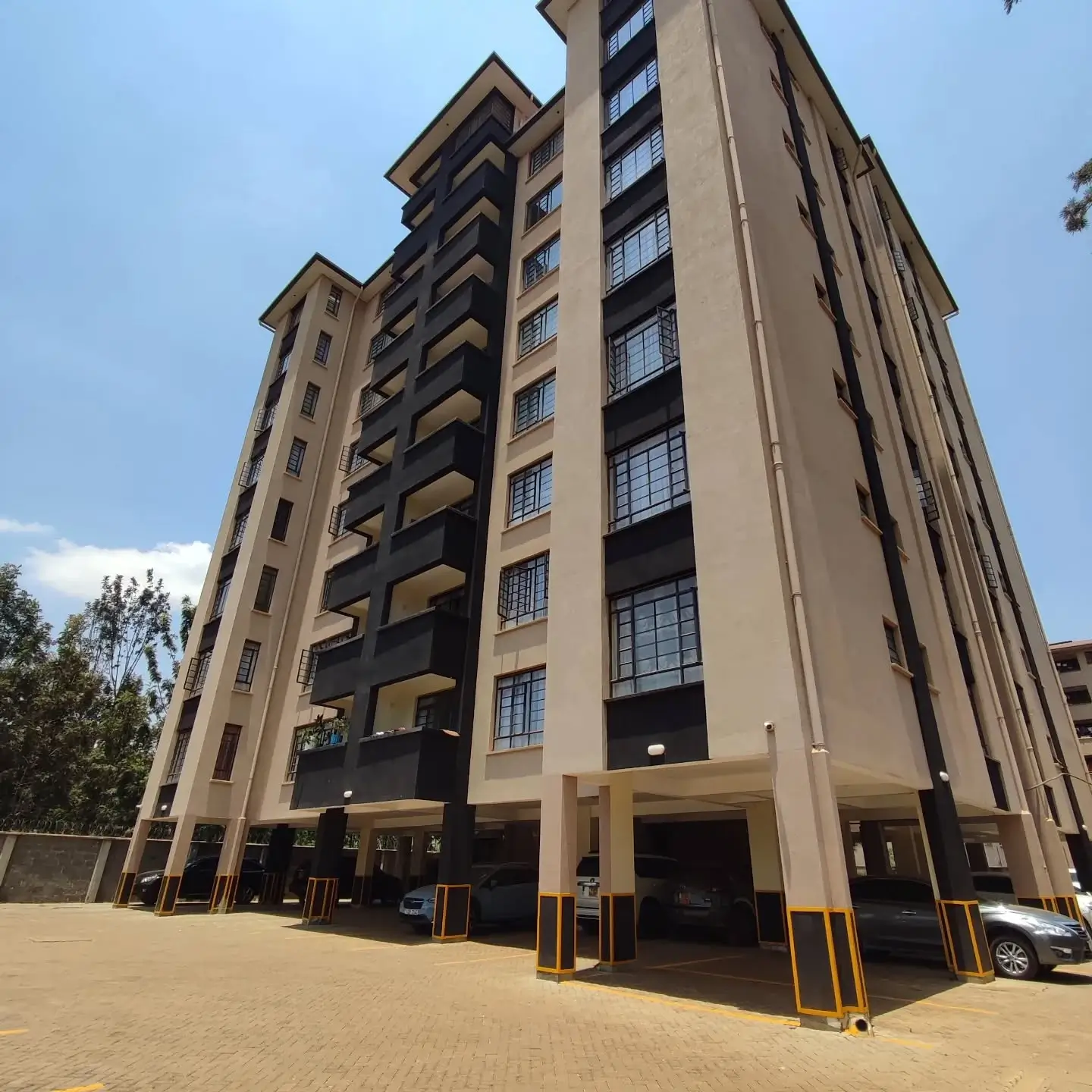 Multi-story residential building with ground-level parking bays