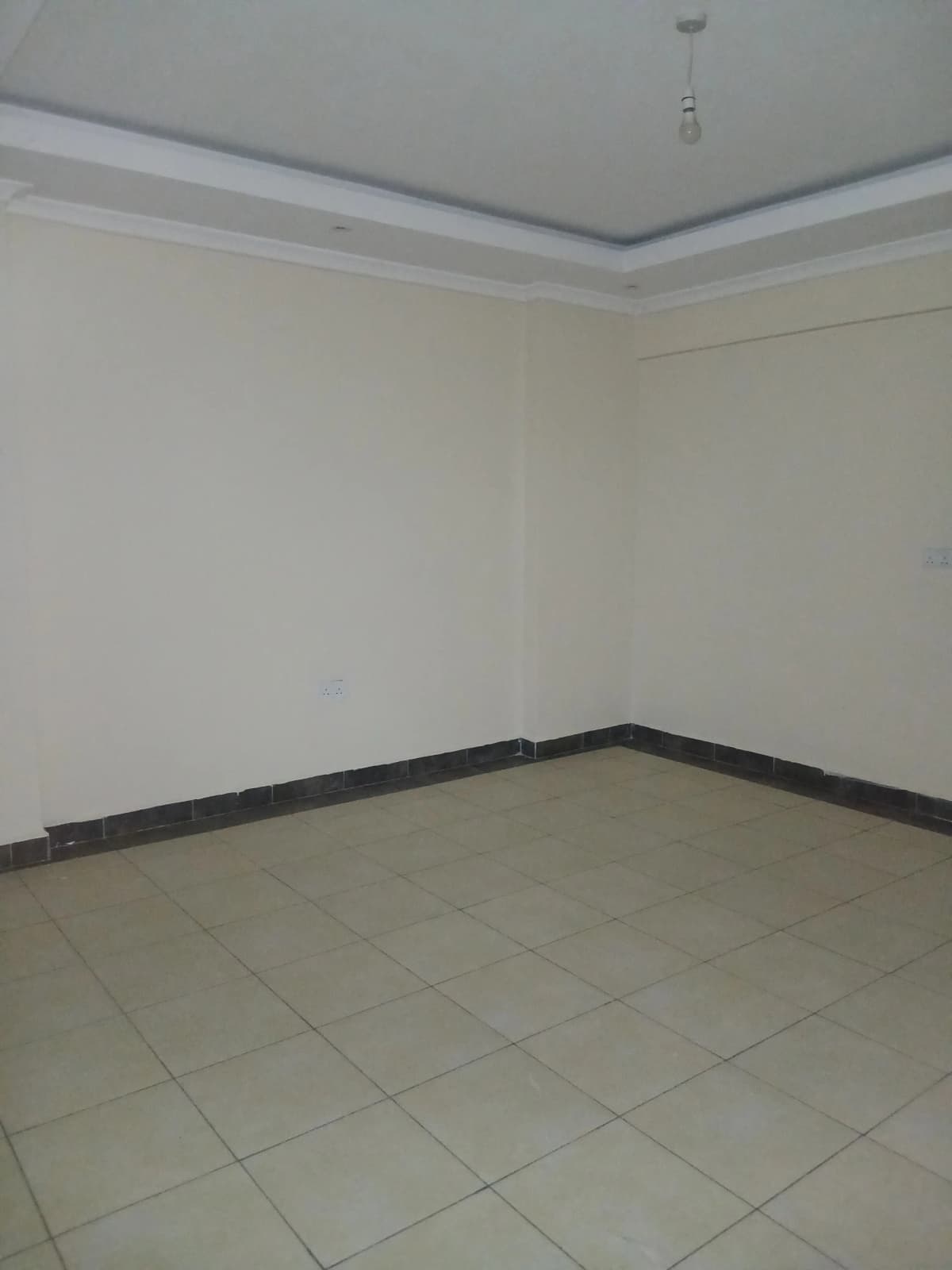 Empty room with tiled floor and white walls