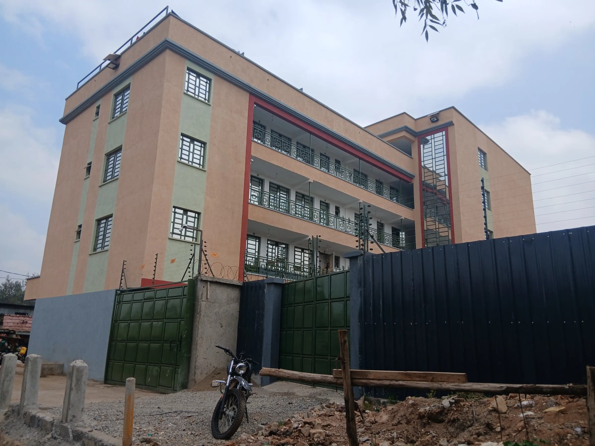 Multi-story residential building facade with green gates