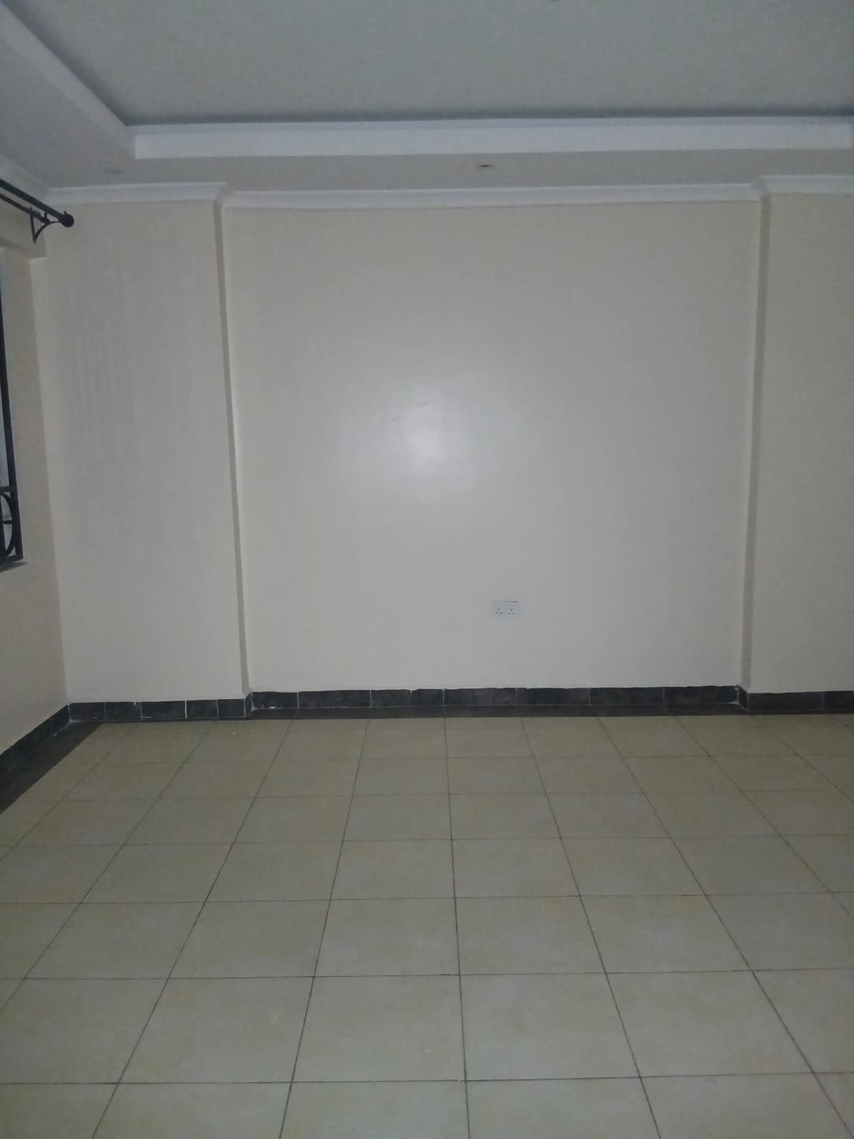 Empty bedroom with tiled floor and white walls