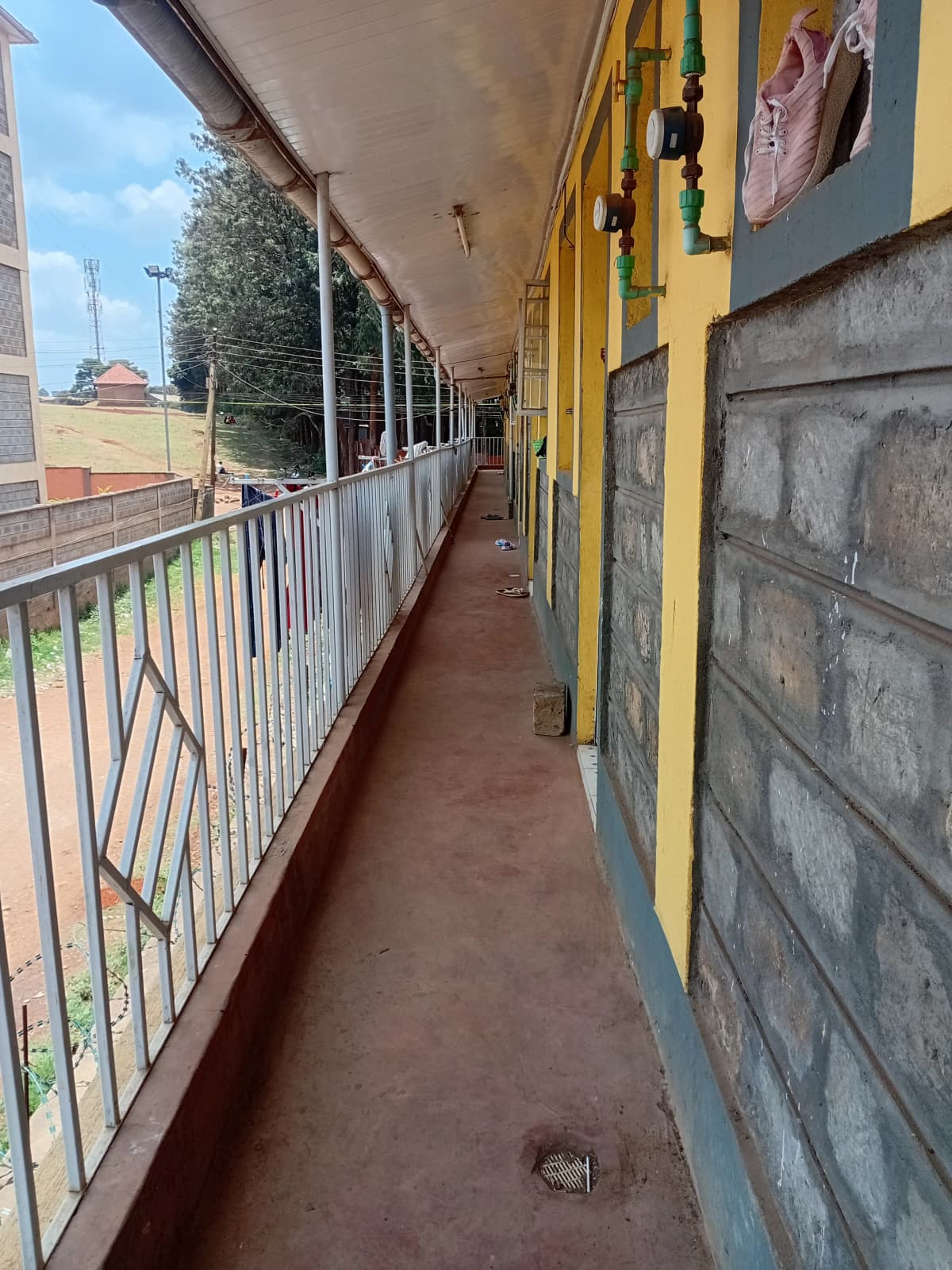 Long covered balcony with metal railings and compound views