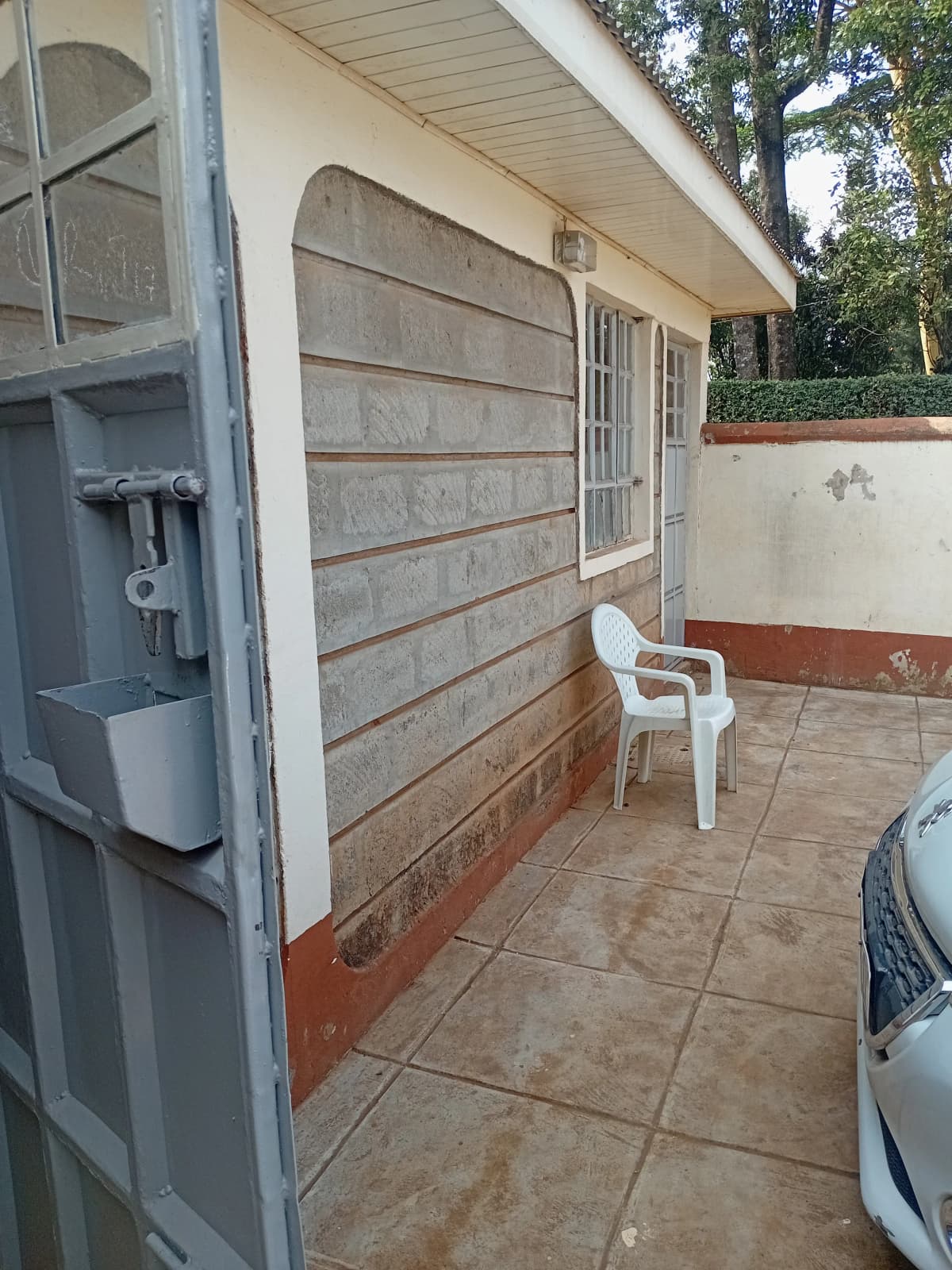 Side compound area with corrugated metal wall and parking space