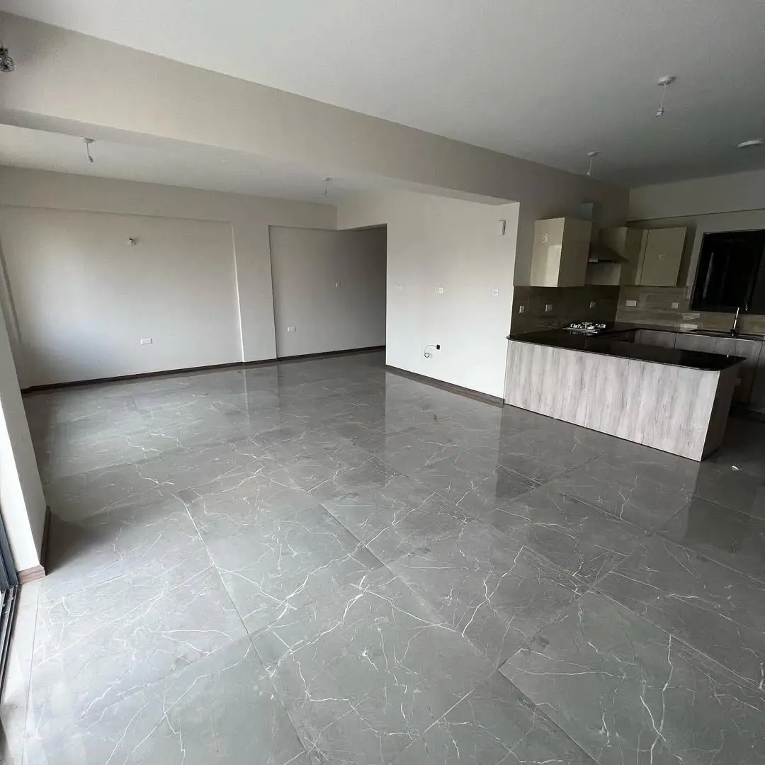 Spacious open-plan living area with marble flooring and kitchen