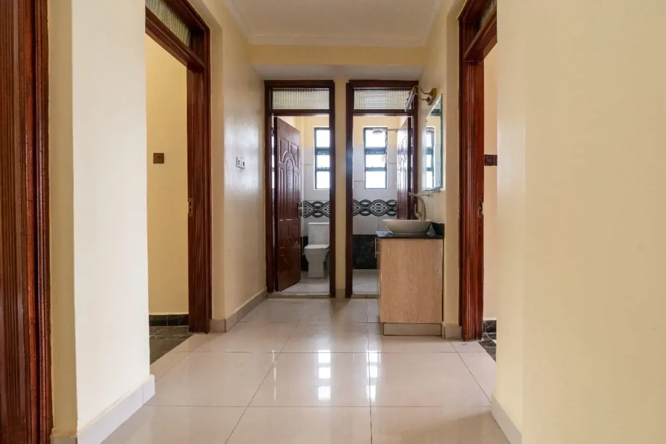 Bright hallway with polished tile floor and wooden doors