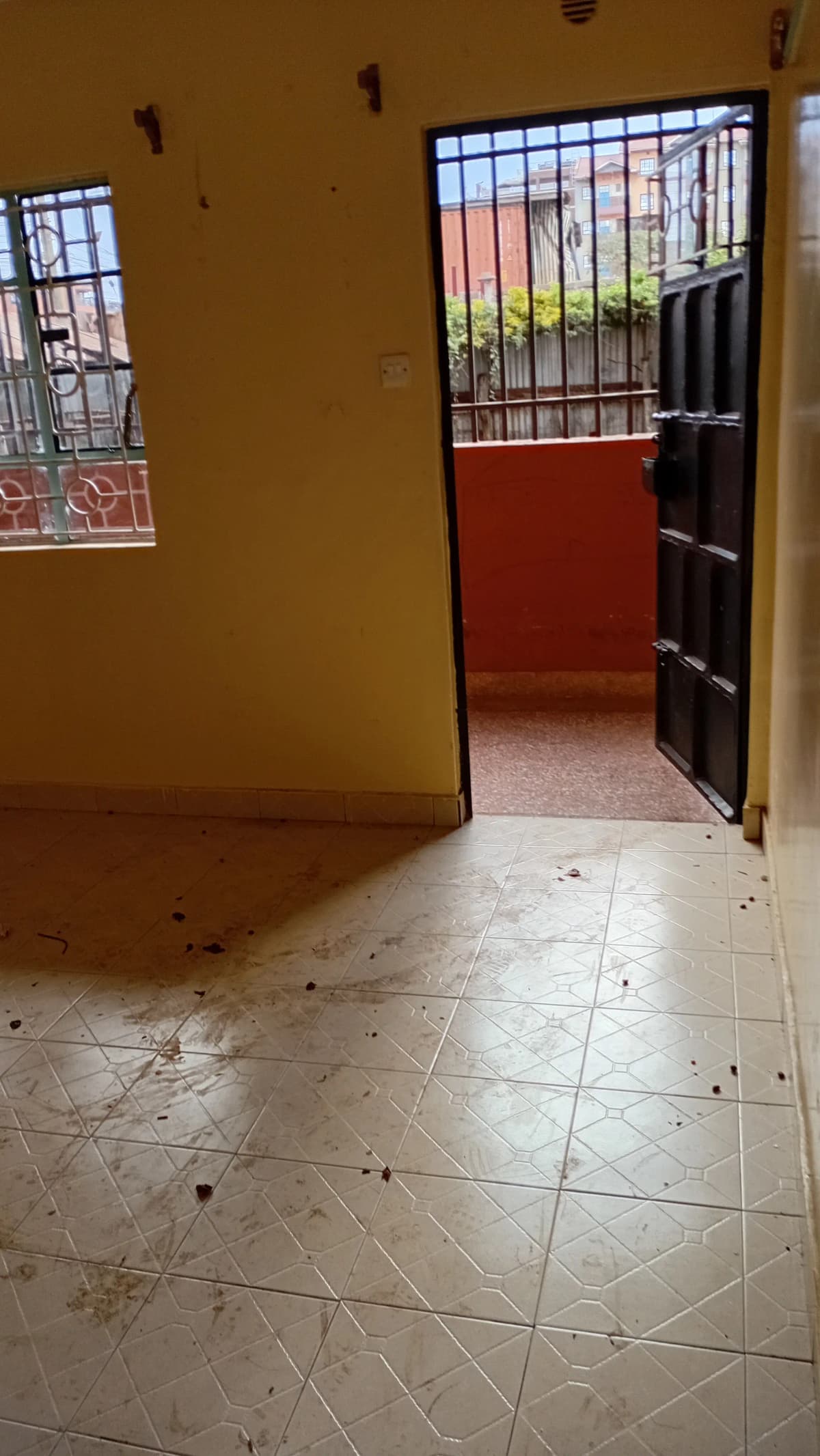 Vacant corridor with tiled floors and barred windows