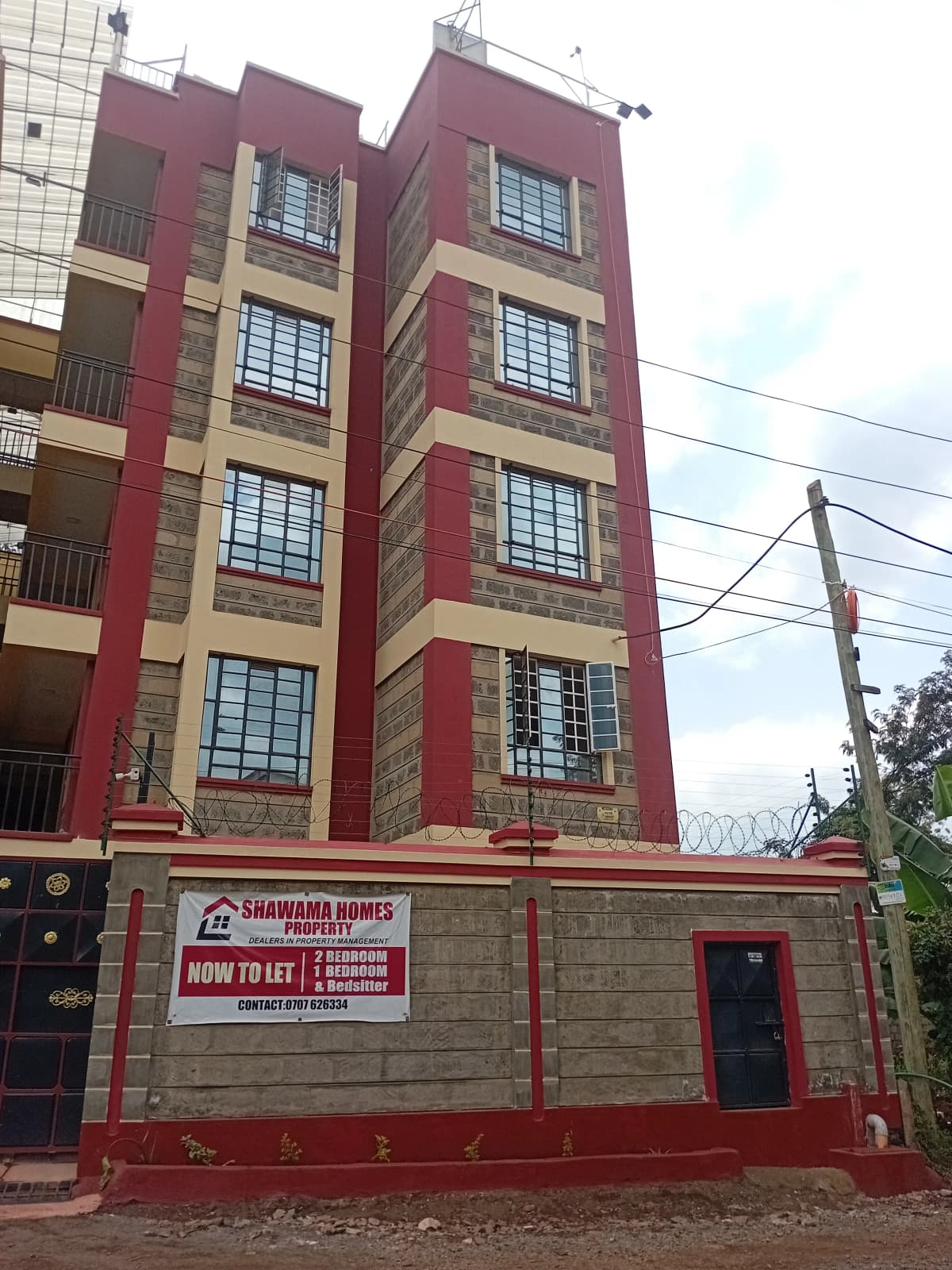Multi-story residential building facade with red and cream coloring