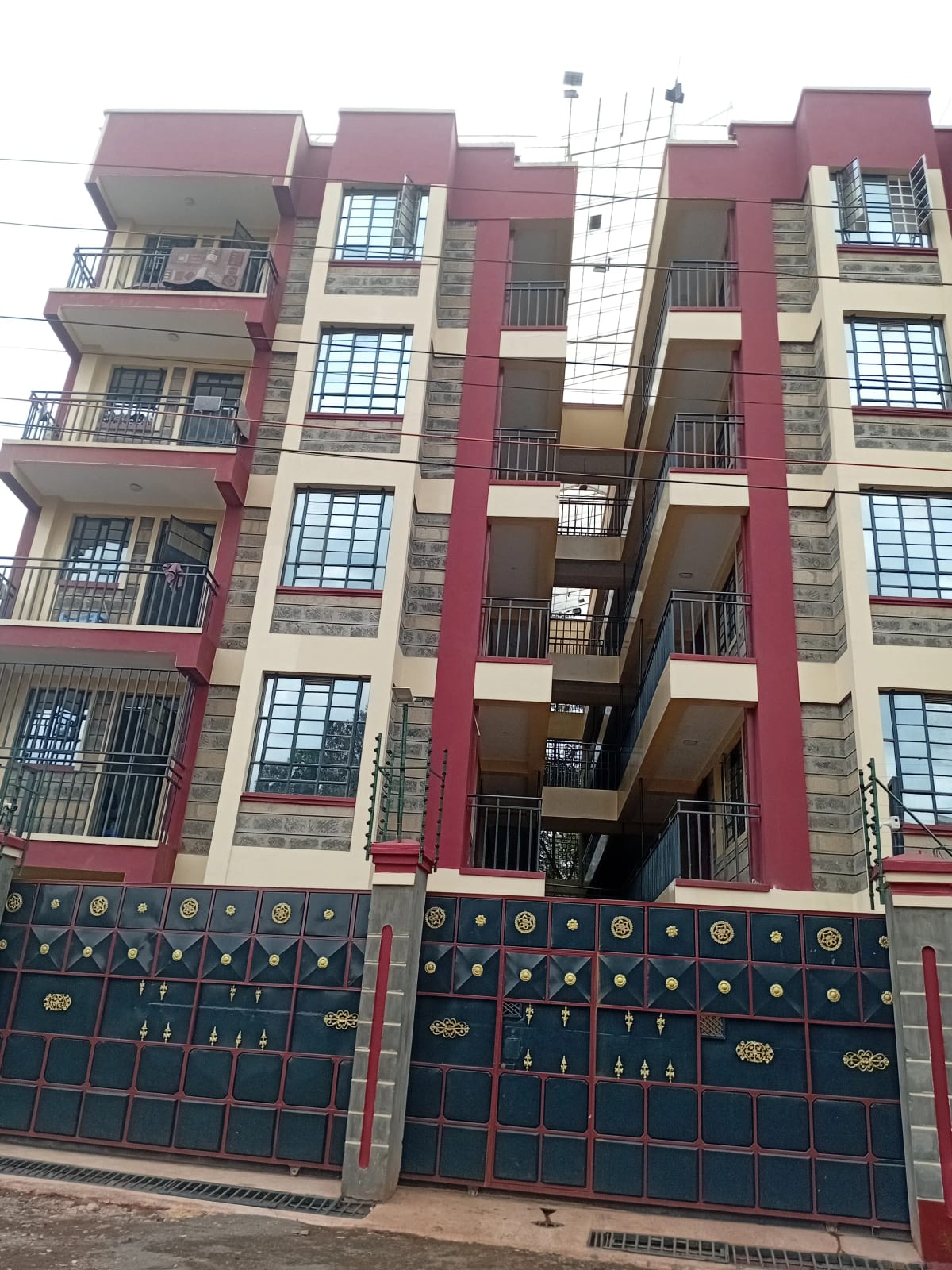 Multi-story residential building facade with ornate compound gates