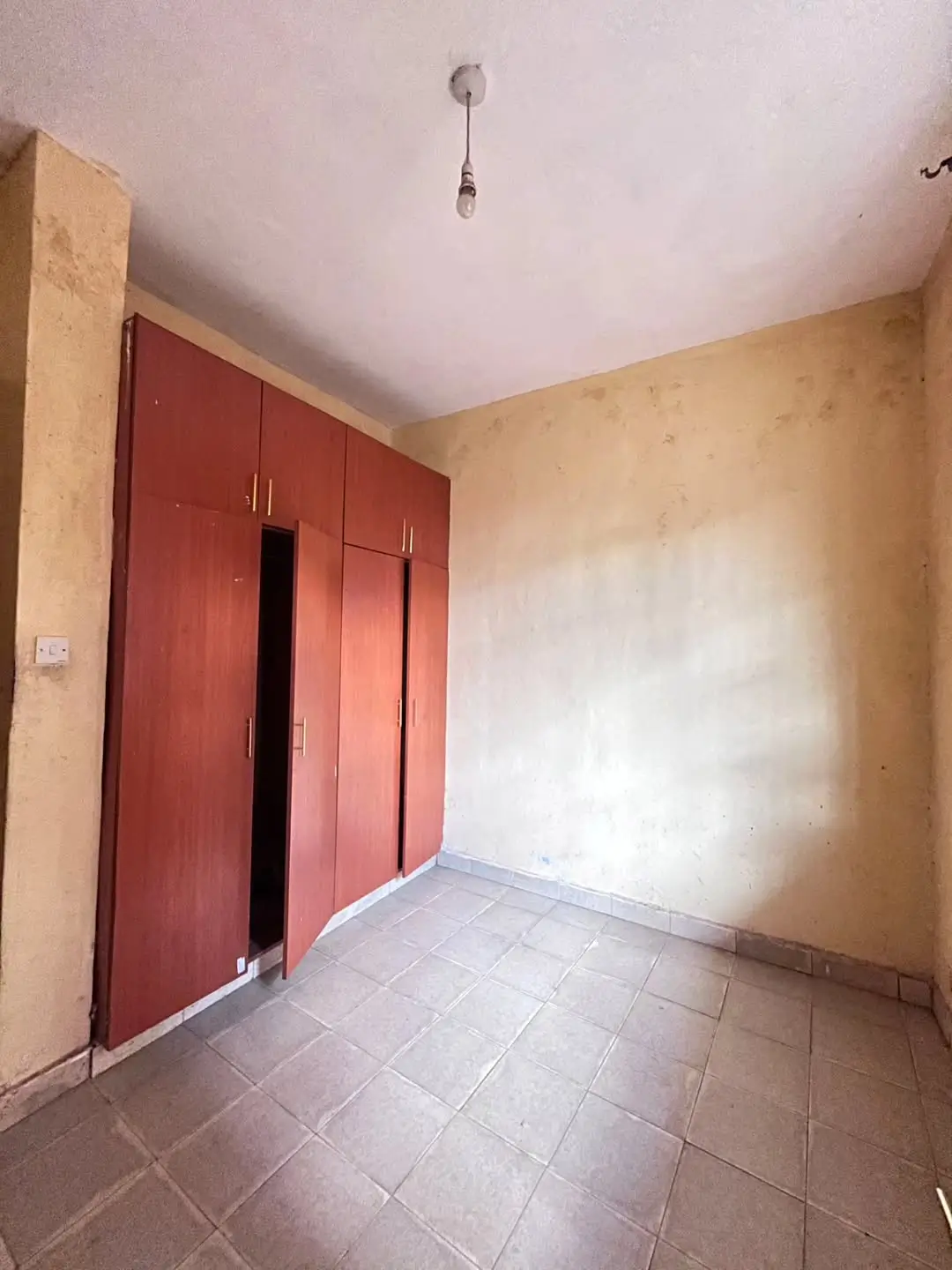 Bedroom with red wardrobe doors and tiled flooring