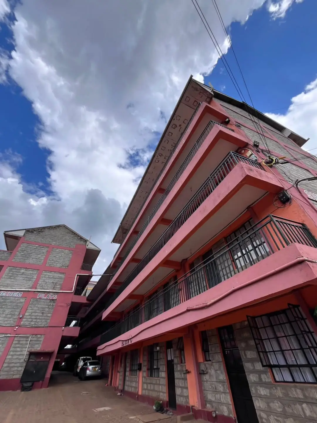 Pink multi-story residential building facade with balconies