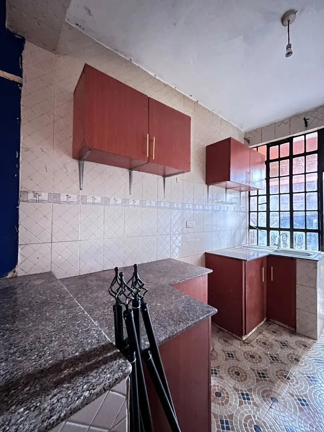 Red cabinetry kitchen with granite counters and white tile backsplash