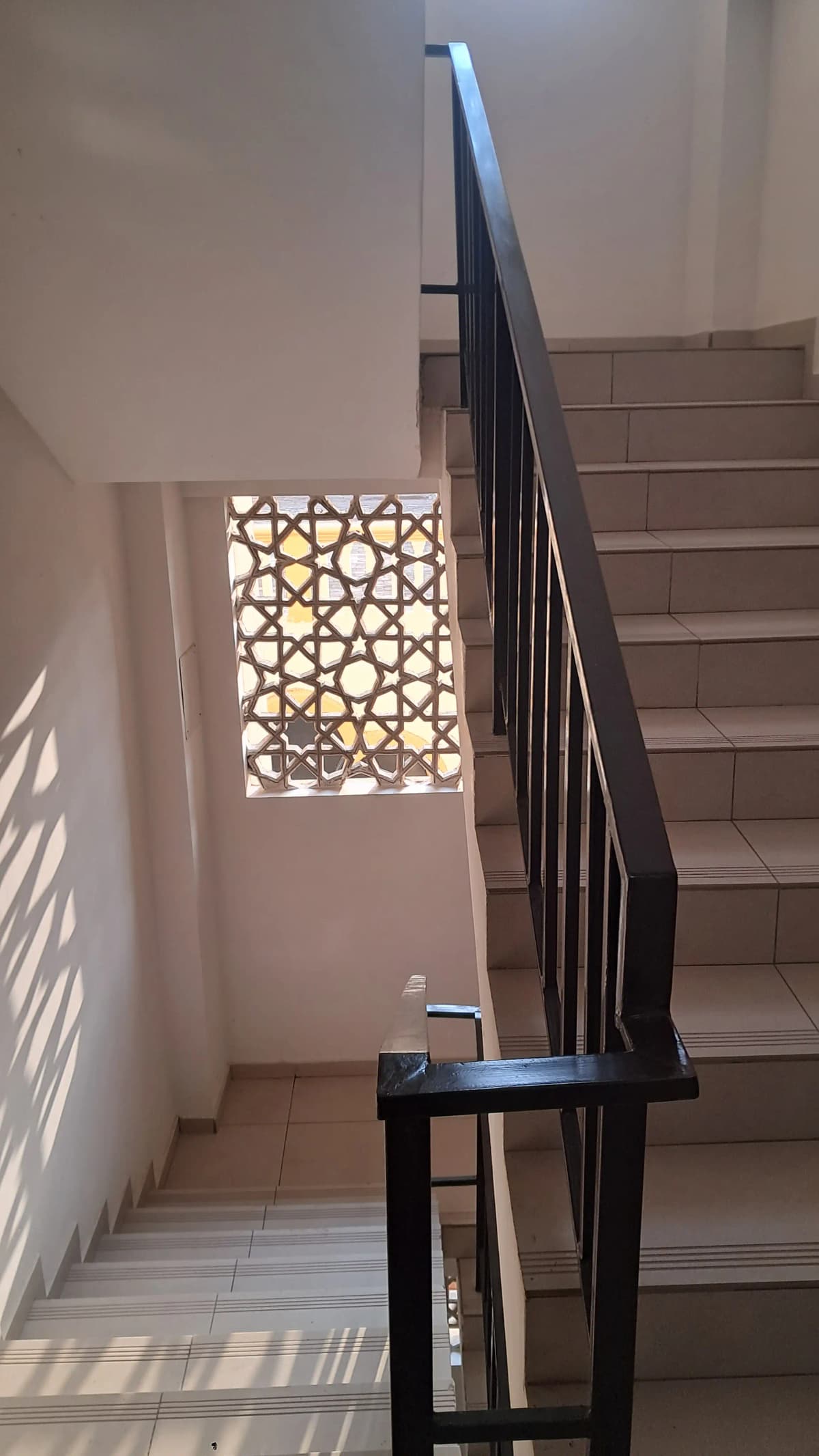 Stairwell with black metal railing and geometric window detail