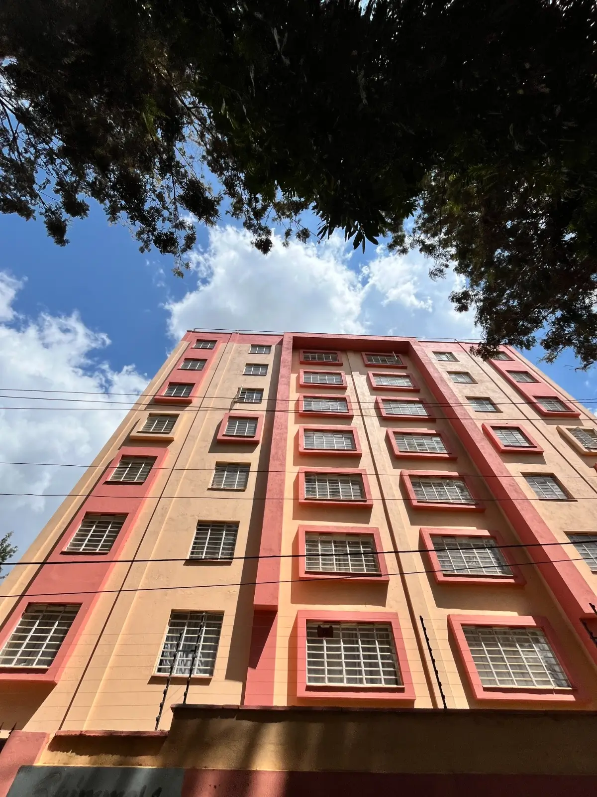 Multi-story residential building facade with coral and peach tones