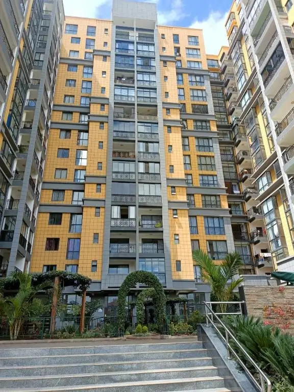 Modern apartment building facade with yellow cladding and balconies