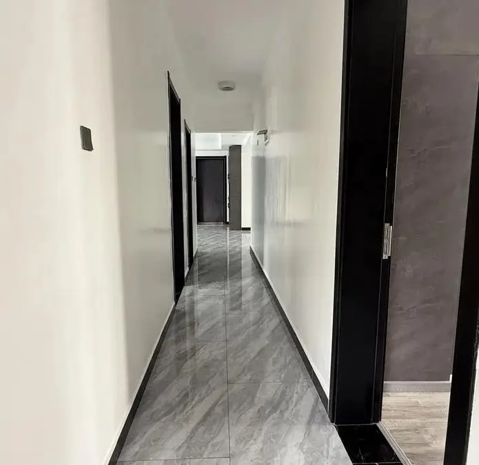 Modern hallway with marble flooring and black doors