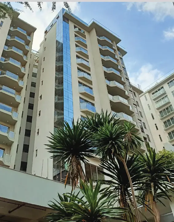 Modern multi-story residential building with balconies and landscaping
