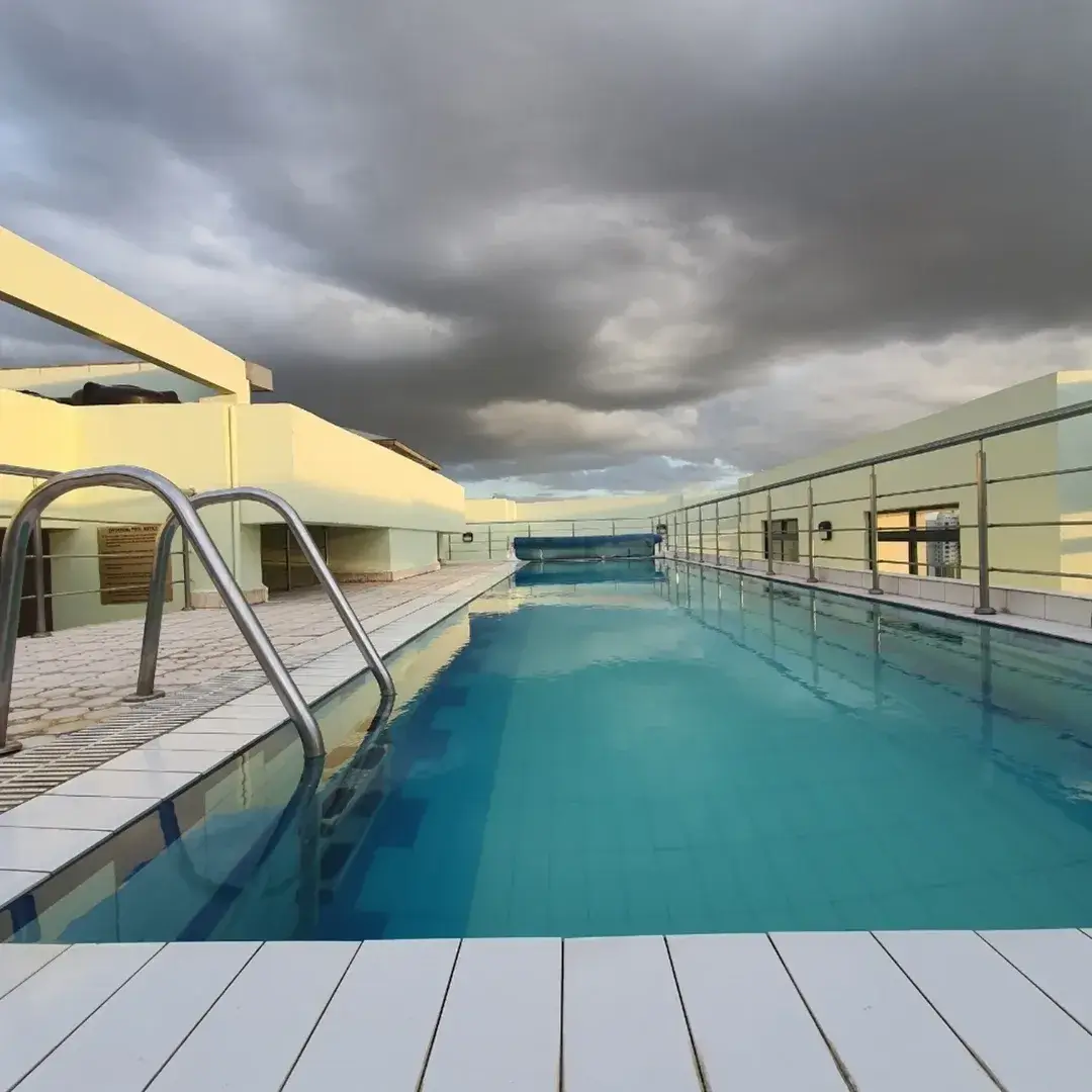 Indoor lap pool with metal railings and yellow building facade