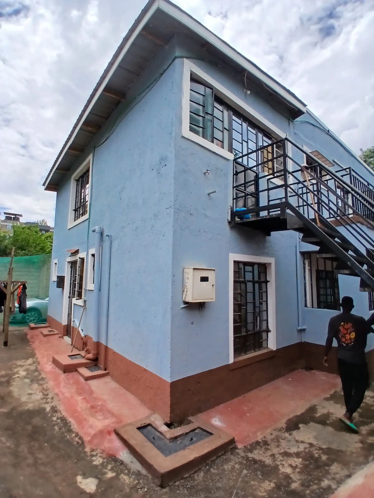Blue and red residential building facade with external staircase