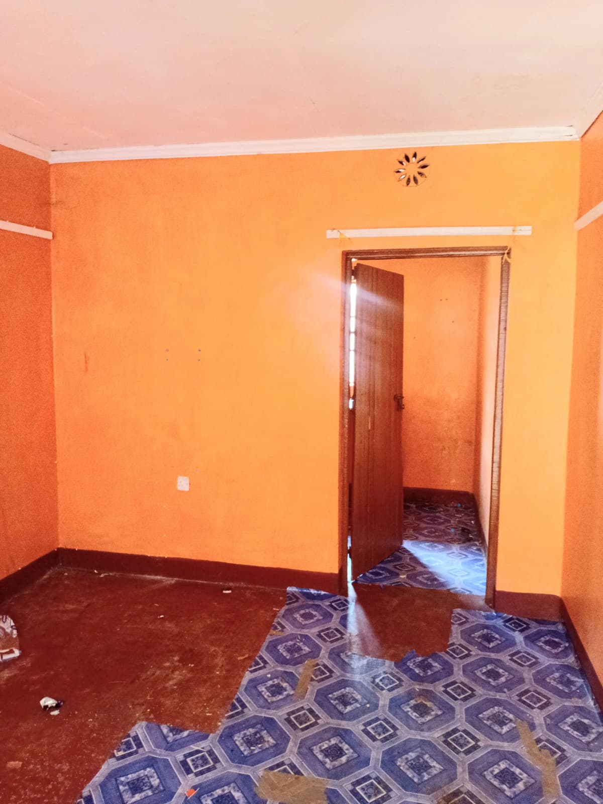Unfurnished bedroom with orange walls and patterned flooring