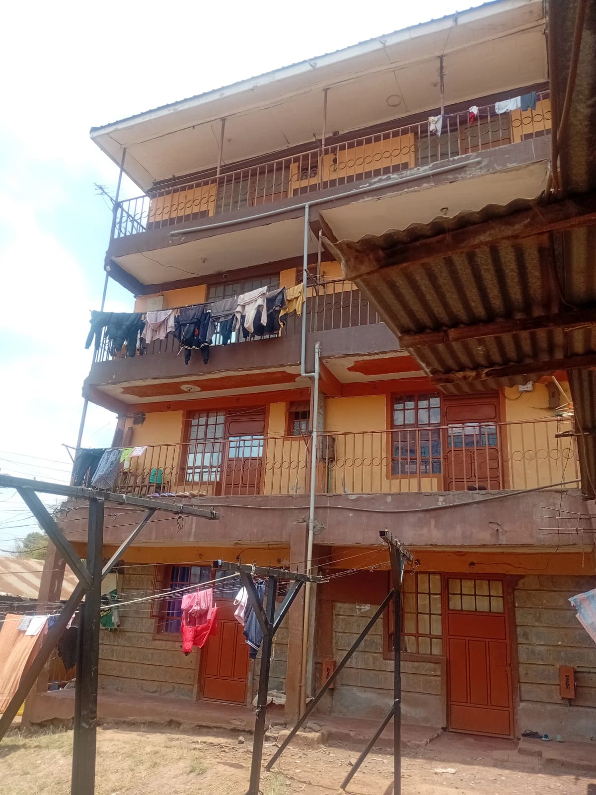 Multi-story residential building with wooden balconies and red doors