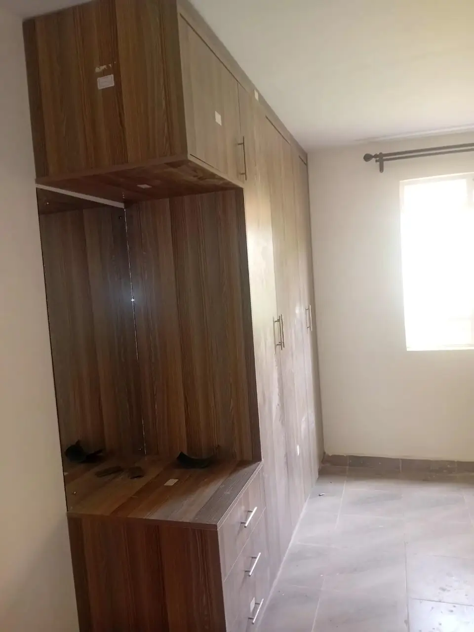 Bedroom with built-in wooden wardrobe and natural light