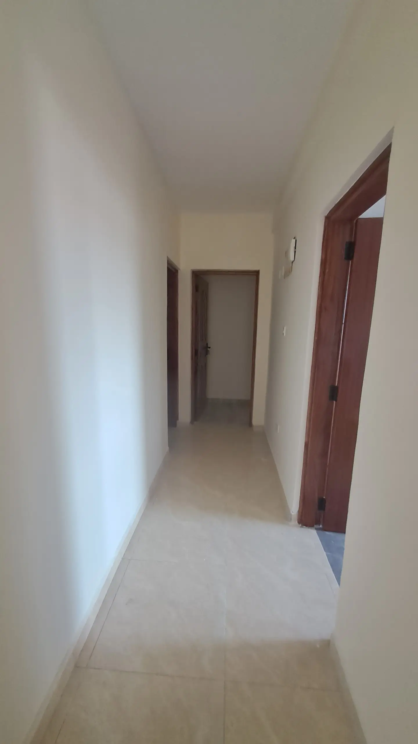 Clean hallway with cream walls and burgundy doors