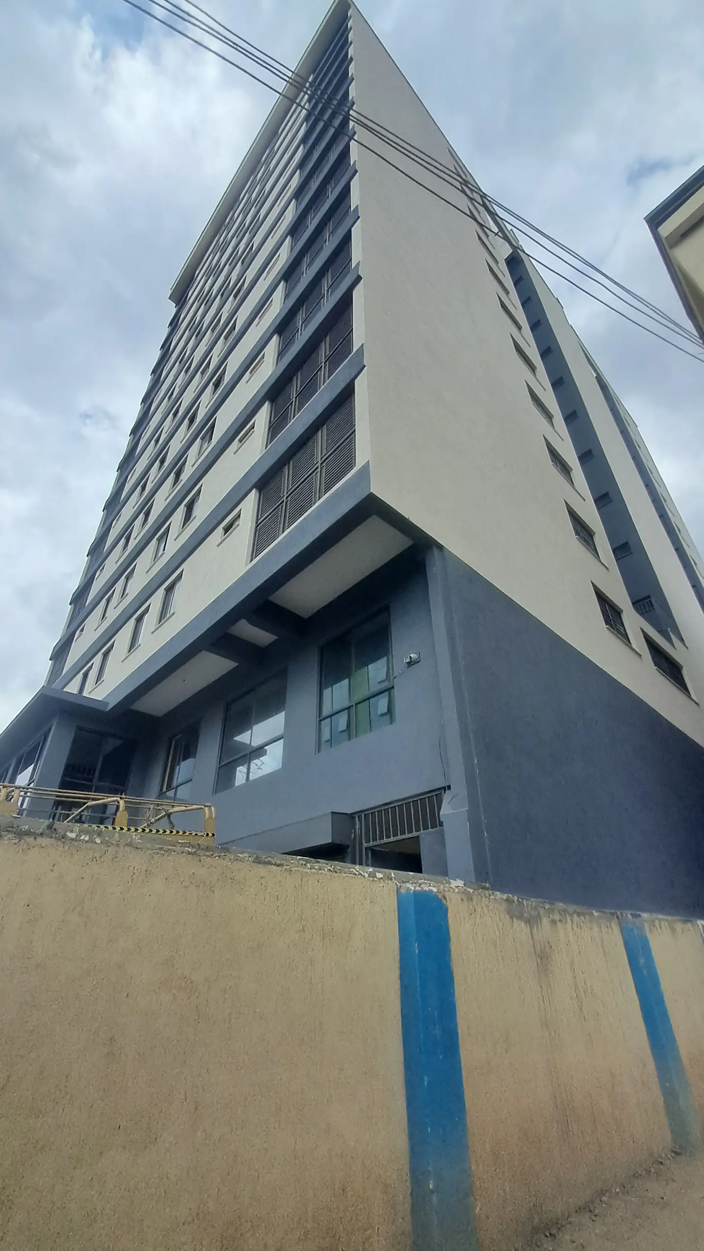 Modern multi-story residential building facade with blue trim