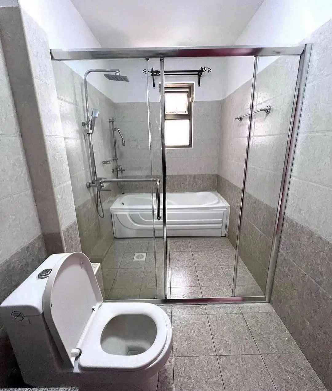 Modern bathroom with toilet, bathtub, and large walk-in shower