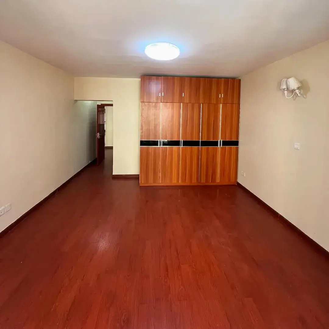 Spacious bedroom with wooden wardrobe and red tile floor