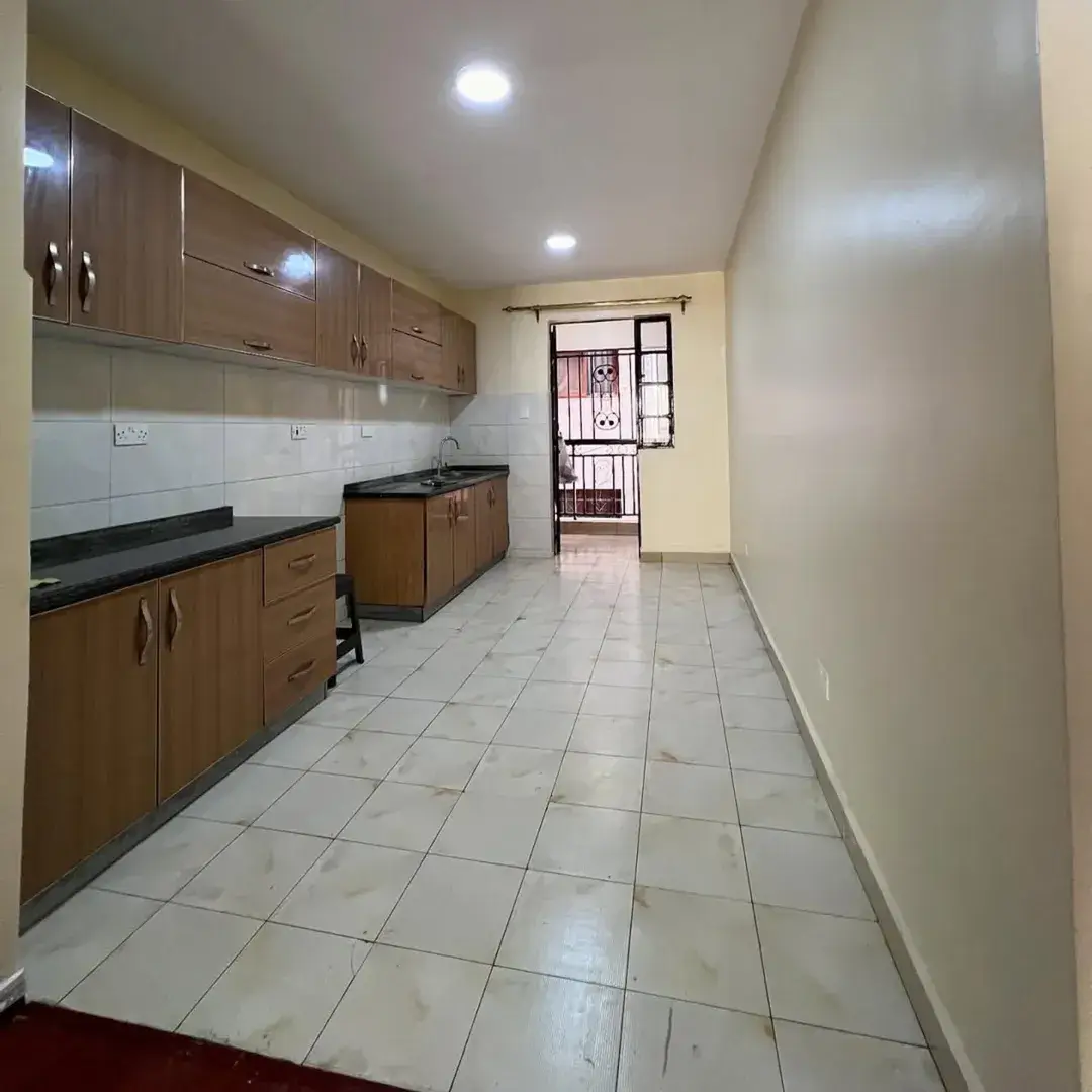 Spacious galley kitchen with wooden cabinets and tile flooring