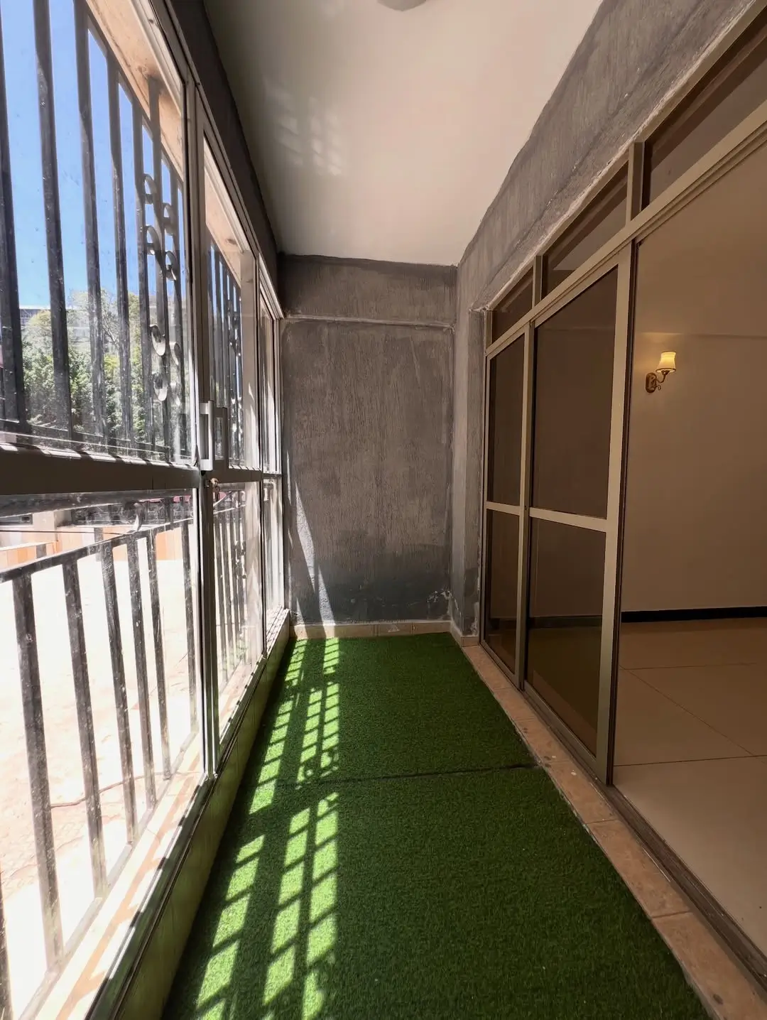 Narrow balcony with artificial turf and metal railings