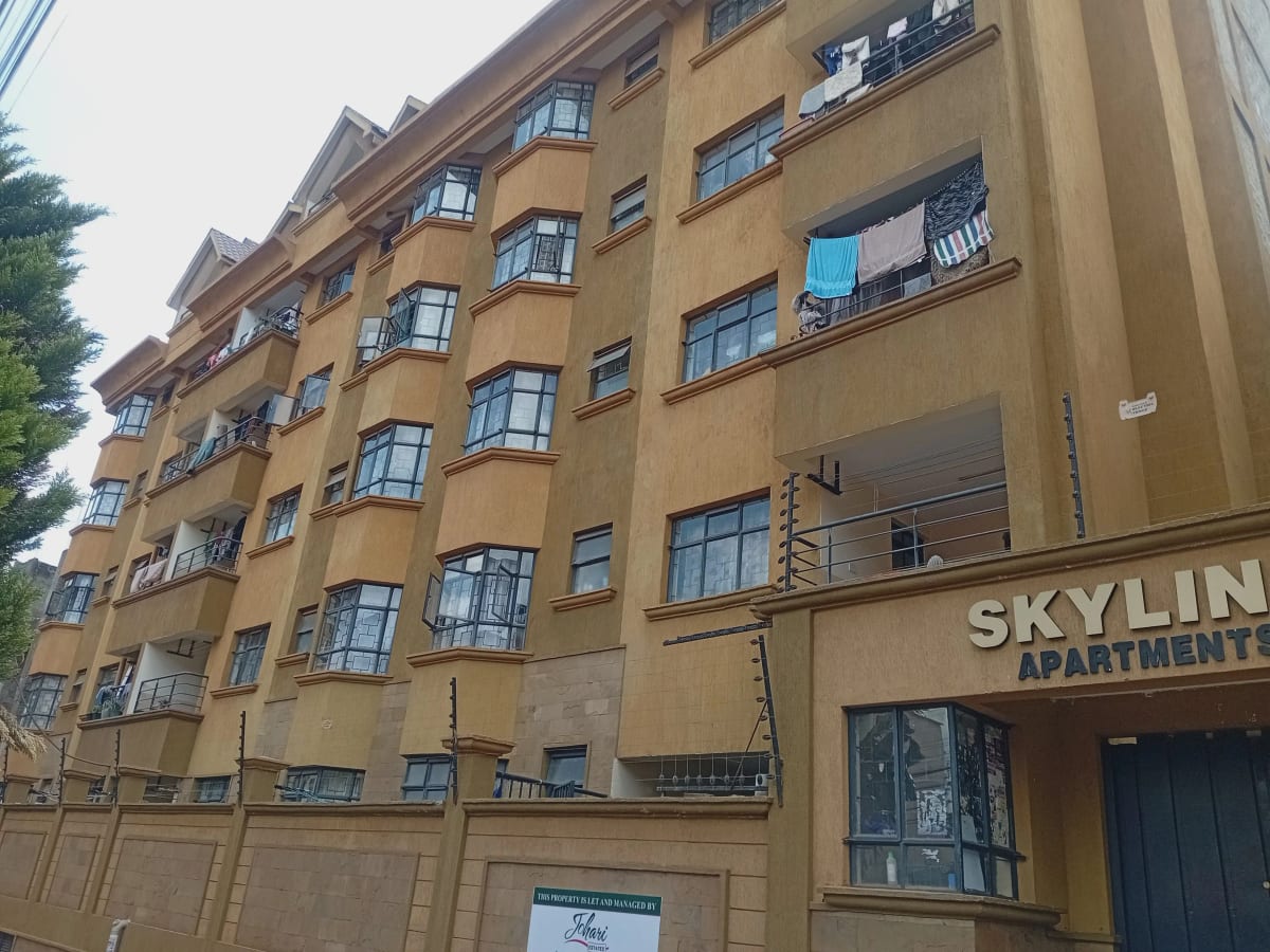 Multi-story residential building facade with balconies and signage